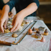 Bakes - handbemaltes Gebäck aus Holz von Grapat neben Kind