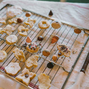 Bakes - handbemaltes Gebäck aus Holz von Grapat liegt auf Gitter mit echtem Gebäck