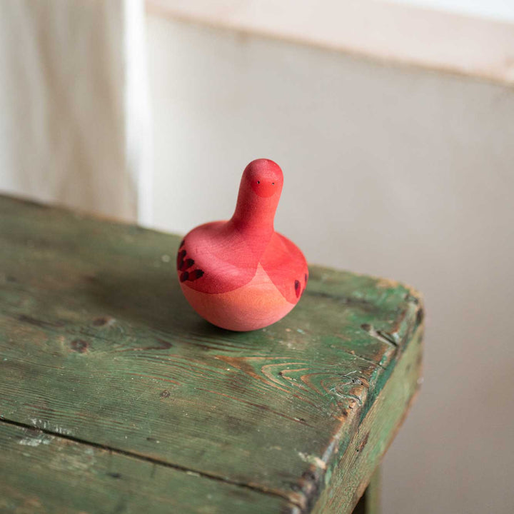Chill Pink Bird von Grapat - pinker Kreisel auf grünem Tisch