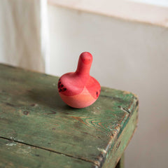 Chill Pink Bird von Grapat - pinker Kreisel auf grünem Tisch