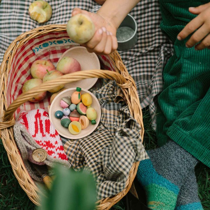 Kind spielt mit Fruits von Grapat: handbemalte Früchte und Obst aus Holz