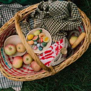 Fruits von Grapat: handbemalte Früchte und Obst aus Holz liegen im Korb neben Äpfel