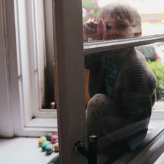 Kind am Fenster mit Happy Eggs von Grapat