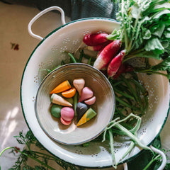 Veggies von Grapat - handbemaltes Holzgemüse liegt neben echtem Gemüse