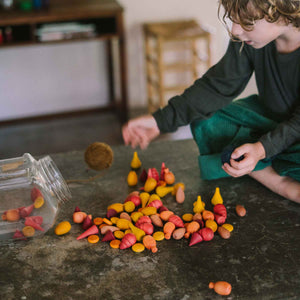 Kind spielt mit Warm Mandala Mix von Grapat - 81 Holzelemente in warmen orange-rot Tönen