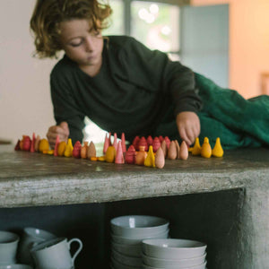 Kind spielt mit Warm Mandala Mix von Grapat - 81 Holzelemente in warmen orange-rot Tönen